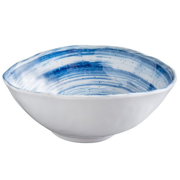 An oval melamine bowl with a white background and blue speckled design.