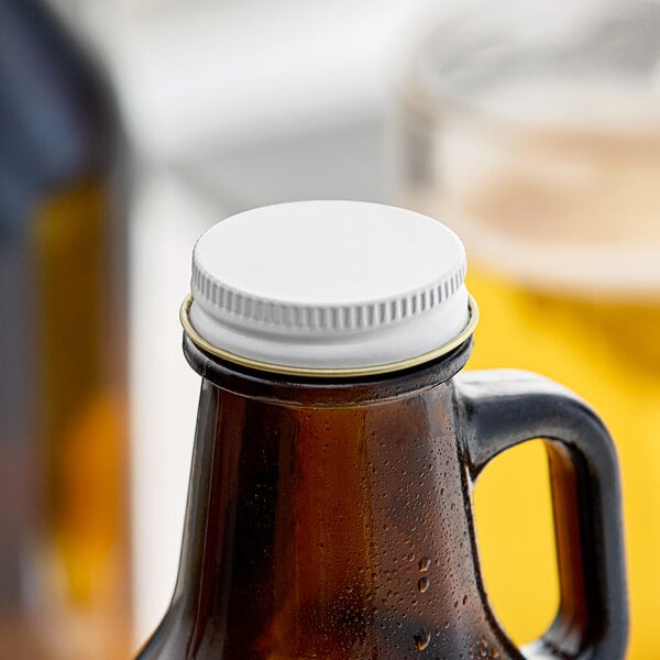 A Libbey beer growler with a white cap on a table.