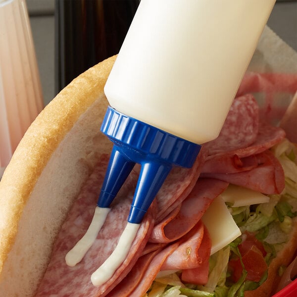 A sandwich with a clear squeeze bottle with a blue cap on it.