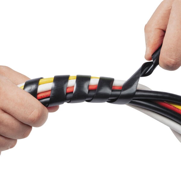 A person's hands using black and white D-Line cable tidy wrap to organize a cable.