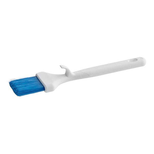 A white Carlisle Sparta Spectrum pastry brush with a blue curved handle.