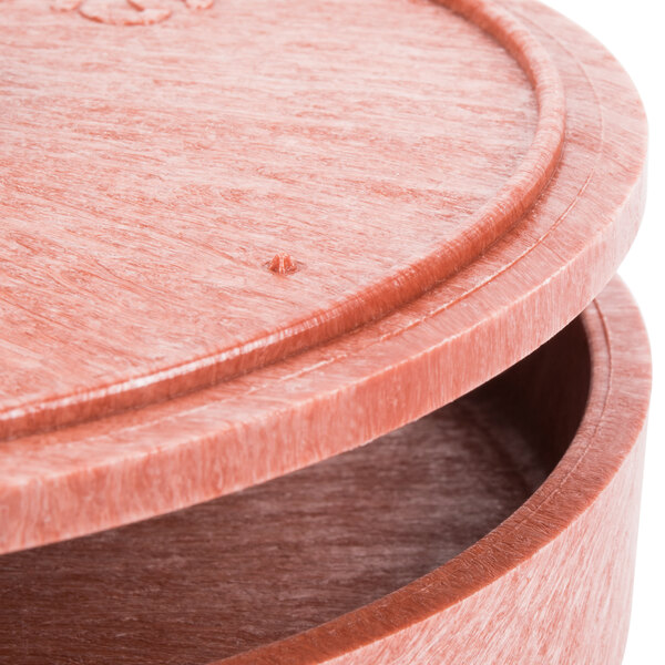 A close up of a round paprika tortilla server with a lid.