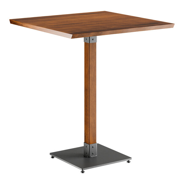 A Lancaster Table & Seating live edge bar height table with a square wooden top and metal base.