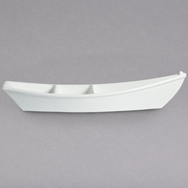 A white boat shaped dish with dividers.