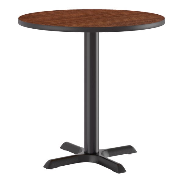 A round standard height table with a reversible walnut or oak top and a black cast iron base.