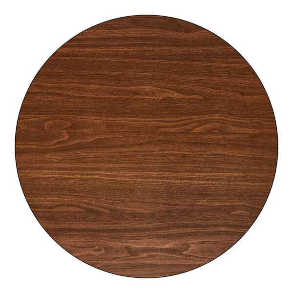 A round, reversible walnut and oak table top with a standard height and a 22-inch by 22-inch cast iron base.