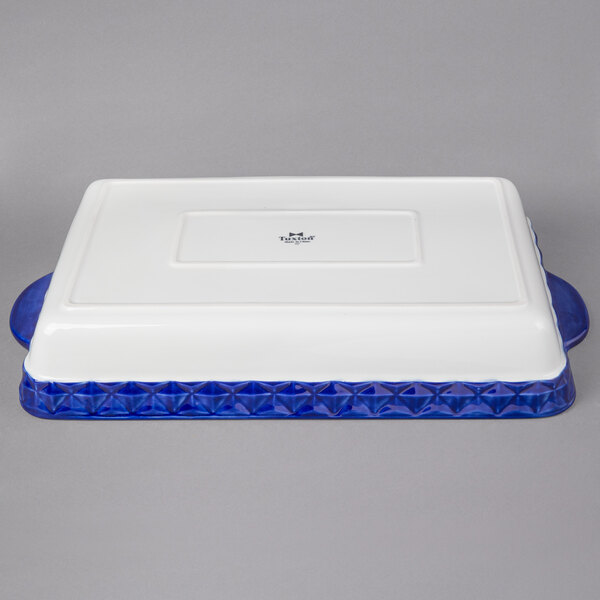 A white rectangular Tuxton casserole dish with a blue border.