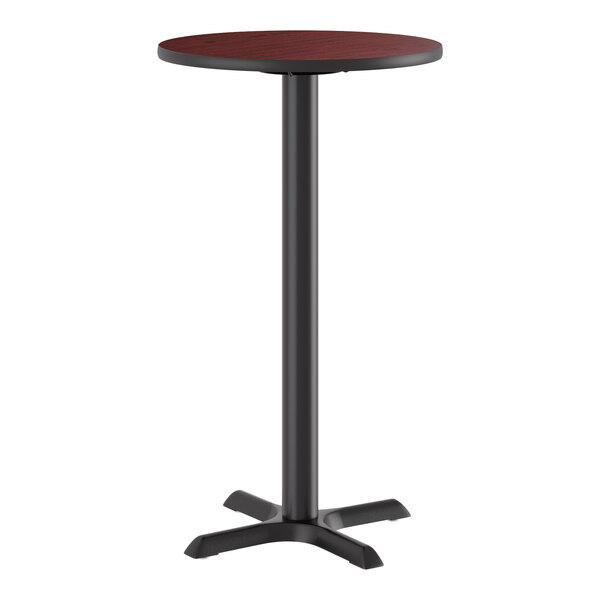 A round bar height table with a reversible cherry and black top and a black cast iron base.