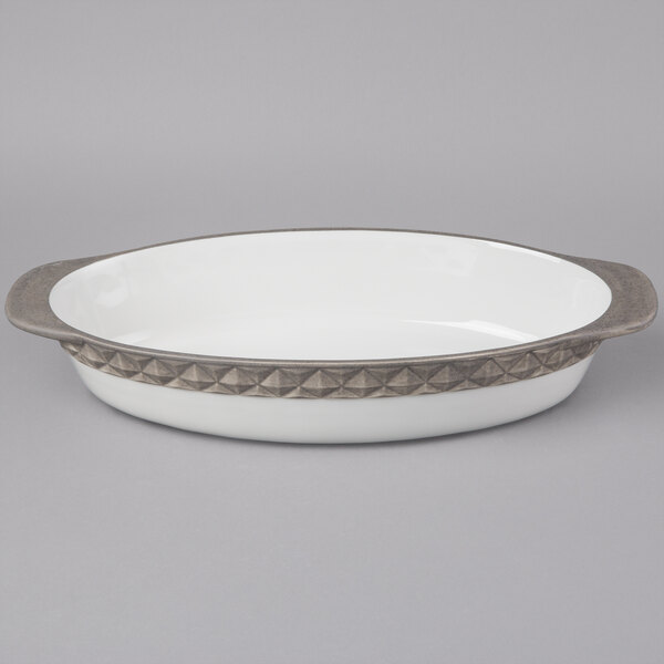 A white oval Tuxton china casserole dish with a silver and gray rim.