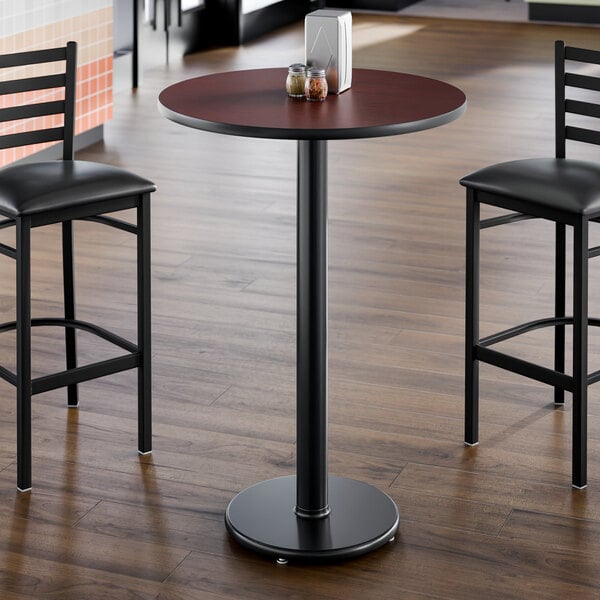 A round bar-height table with a cherry and black reversible top and a sturdy cast iron base.