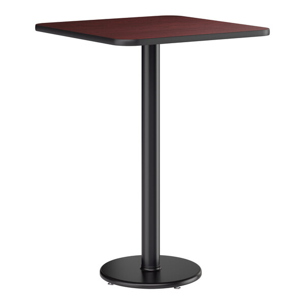 A square bar height table with a reversible cherry and black top and a round black cast iron base.