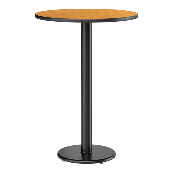 A round bar height table with a reversible walnut and oak top and a black cast iron base.