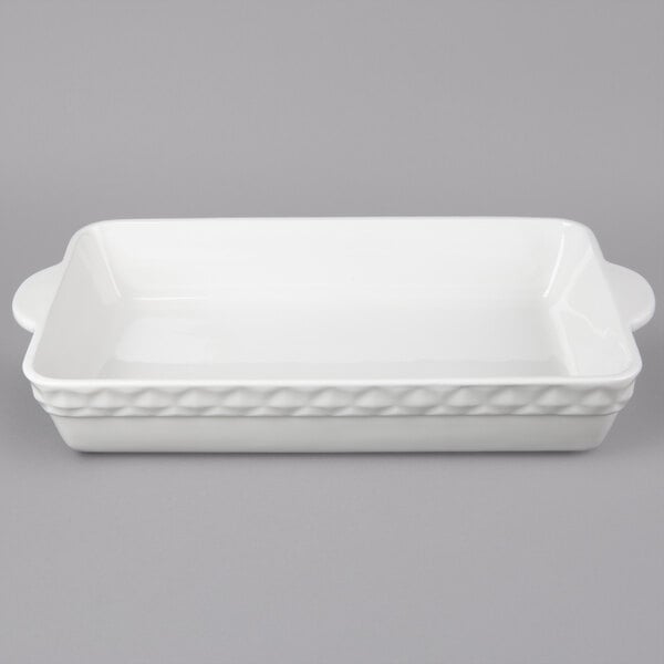 A white rectangular Tuxton casserole dish with handles.