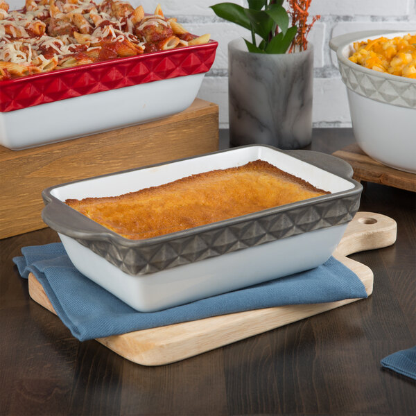 A Tuxton rectangular black and white casserole dish with pasta and sauce.