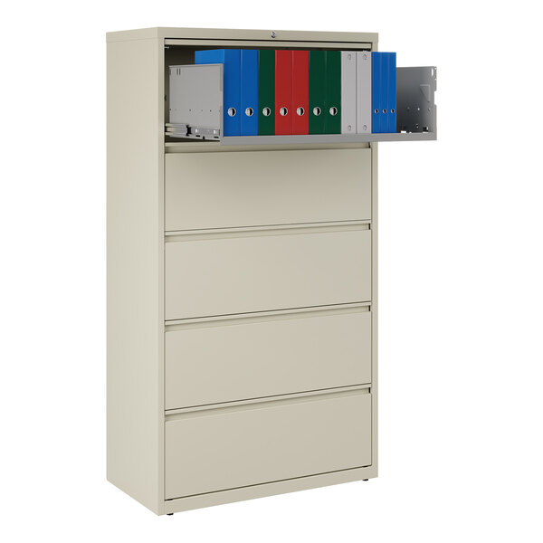 A five-drawer putty-colored lateral file cabinet with a roll-out binder storage shelf containing several binders.