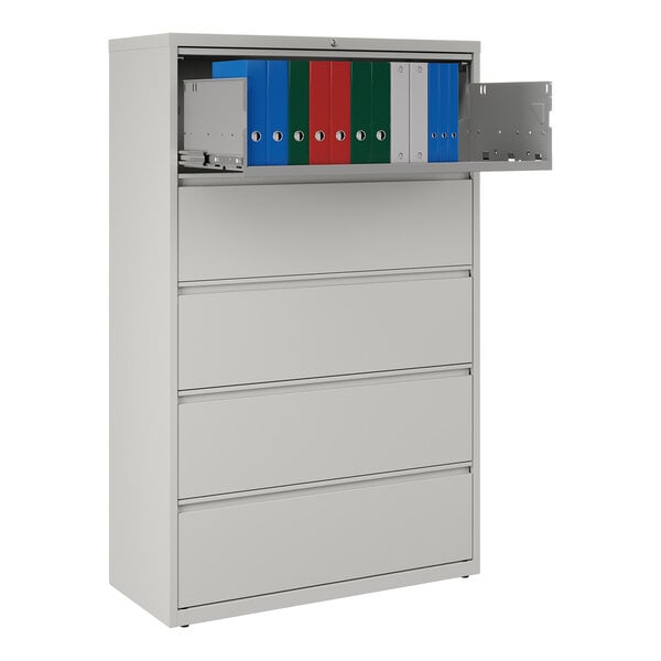 A gray five-drawer lateral file cabinet with a roll-out binder storage shelf at the top.