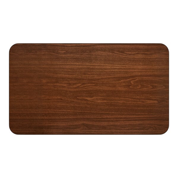 A rectangular reversible walnut and oak table top with rounded corners.