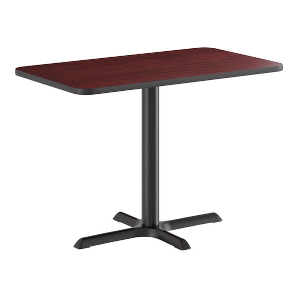 A rectangular standard height table with a reversible cherry and black top and a black cross cast iron base.