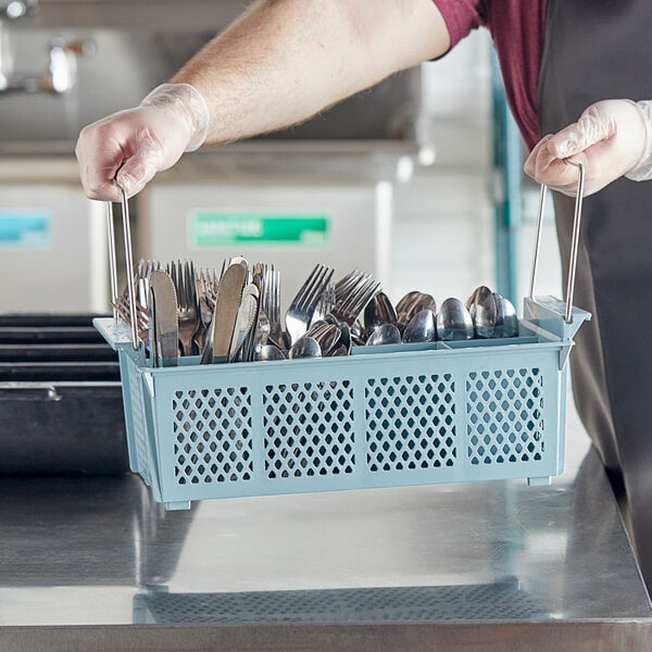 A person holding a Noble Products flatware rack full of silverware.