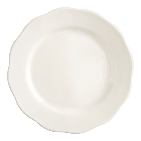 An ivory stoneware plate with a scalloped edge and a round center.