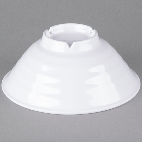 A white bowl with a hole on a gray surface.