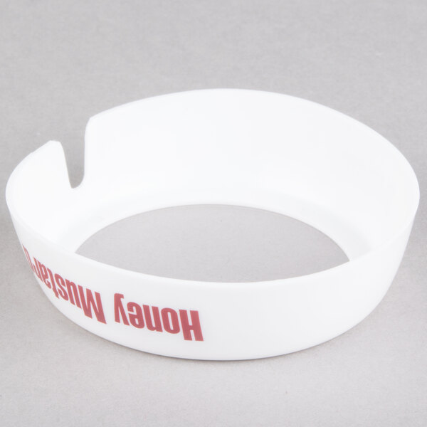 A white plastic Tablecraft salad dressing dispenser collar with maroon text reading "Honey Mustard"