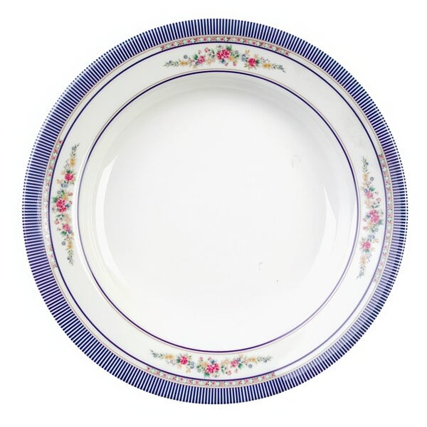 A white plate with blue and white rose design on the rim.