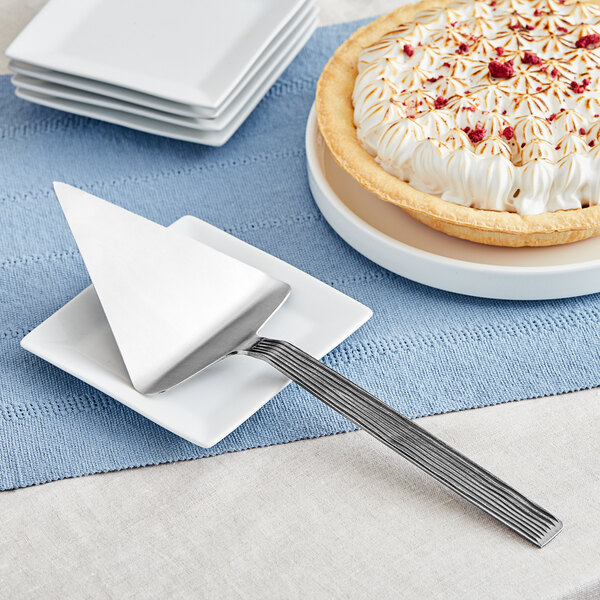 A pie on a plate with a silver wavy spatula.