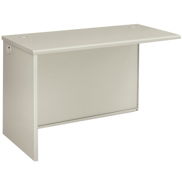 A silver mesh and light gray laminate return shell for a desk.