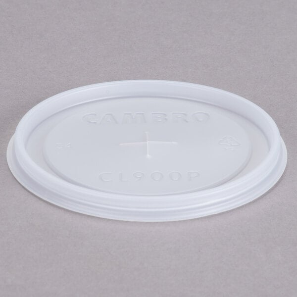 A white plastic Cambro lid with a straw slot and a cross on it.