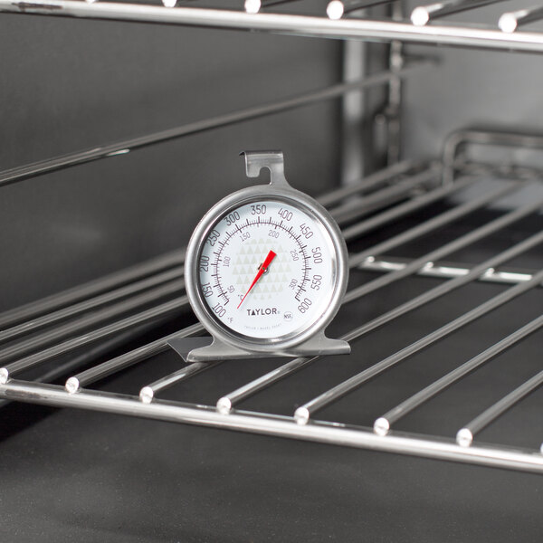 A Taylor oven thermometer on a rack in the oven.