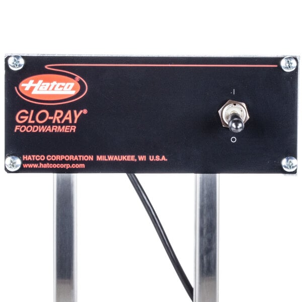 A stainless steel rectangular Hatco Glo-Ray warmer with red text on a black rectangular sign.