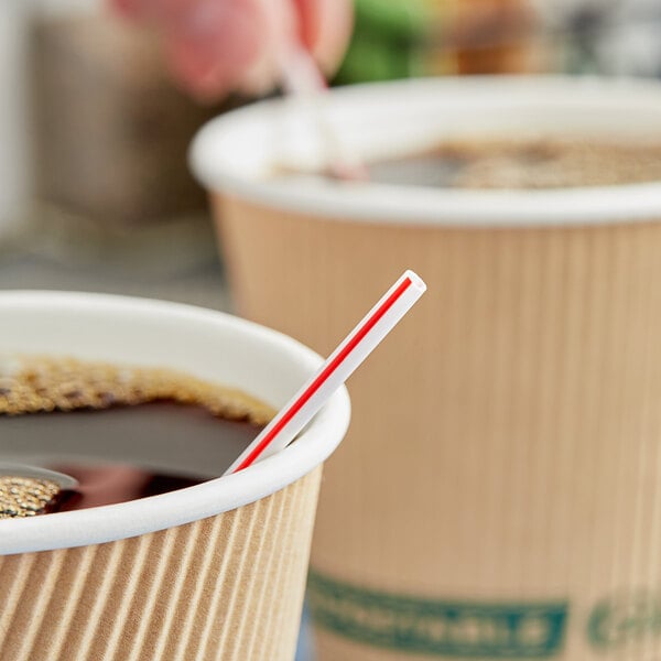 A red and white Choice coffee stirrer in a cup of coffee.