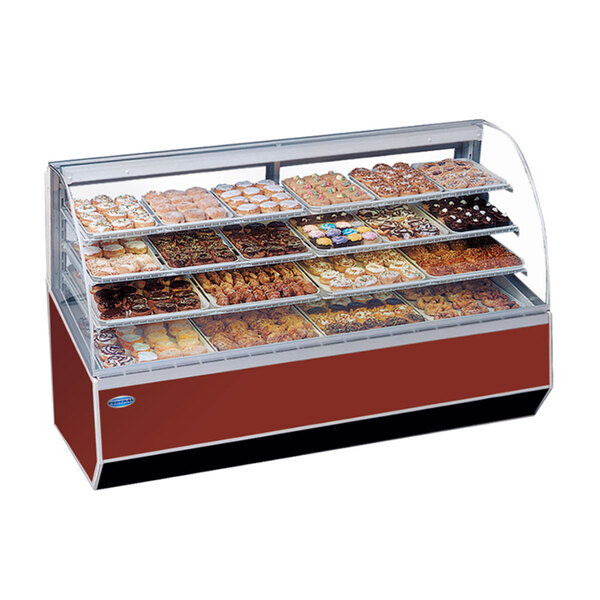 A Federal Industries Series '90 double-curved glass dry bakery case on a counter in a bakery display filled with different types of pastries.