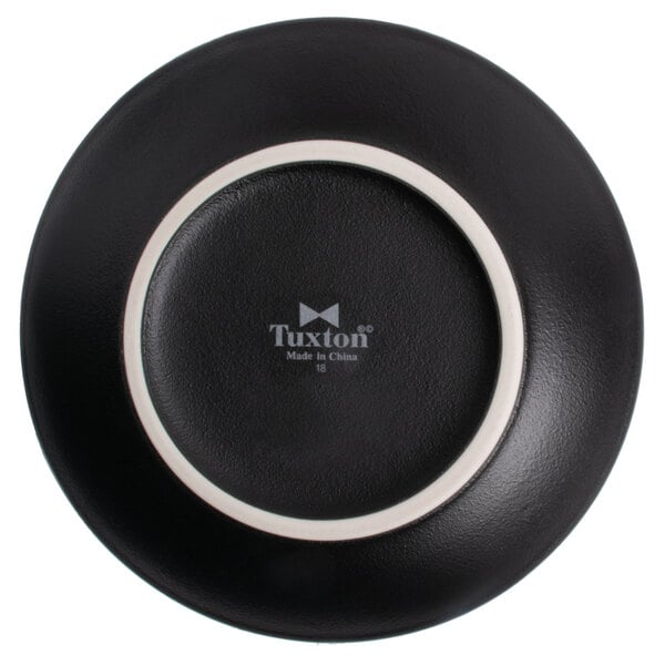 A matte black Tuxton bread and butter plate with a white rim.