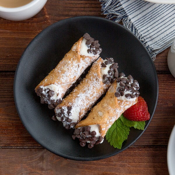 A Tuxton TuxTrendz matte black coupe plate with chocolate covered pastries with strawberries.