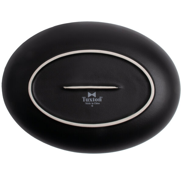 A black oval Tuxton China bowl with white embossed trim.