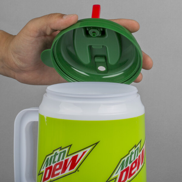 A hand holding a green lid over a green and white Mountain Dew Mini Tanker.