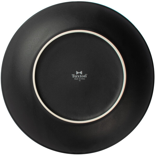 A Tuxton matte black china plate with a white border.