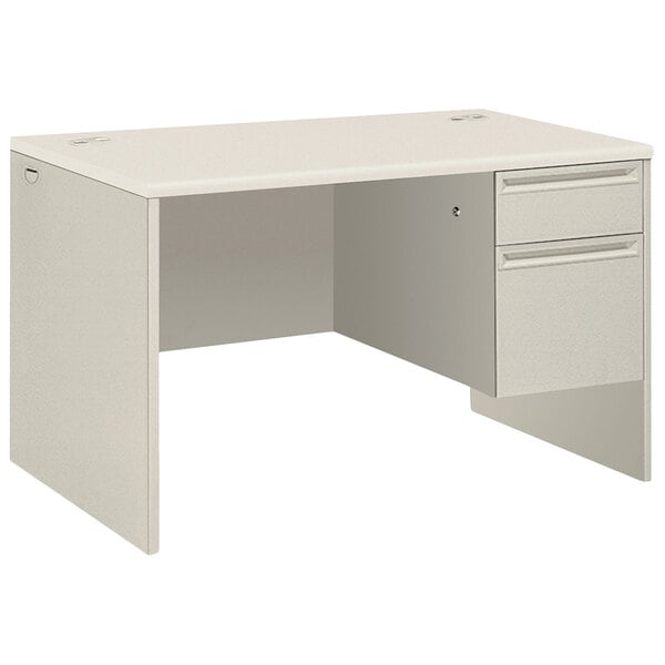 A silver mesh and light gray laminate HON 3/4 height single pedestal desk with a drawer.