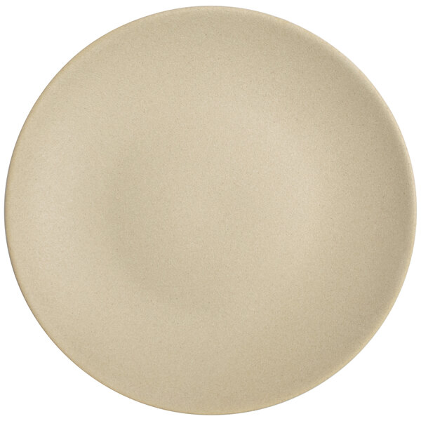 A close up of a Tuxton Zion matte beige coupe china plate.