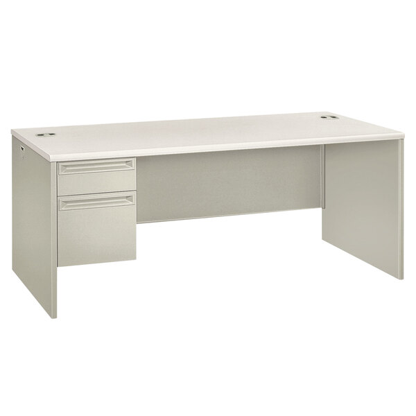 A white HON 38000 series single pedestal desk with drawers.