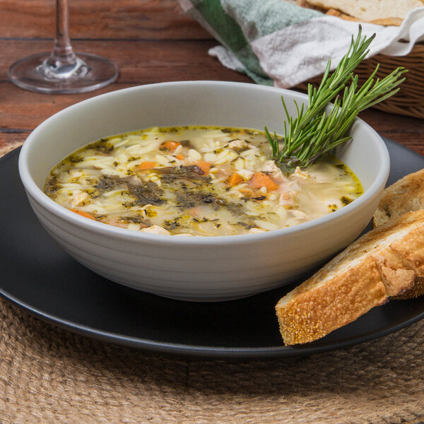 A Tuxton TuxTrendz matte gray china bowl filled with soup and bread.