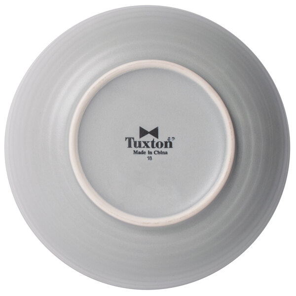 A close-up of a TuxTrendz matte gray china bowl with an embossed design.