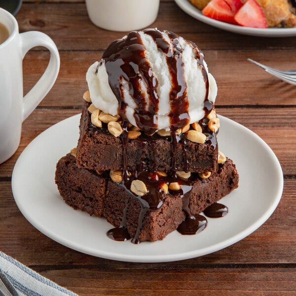 A Tuxton TuxTrendz white coupe plate with brownies, ice cream, and chocolate sauce.