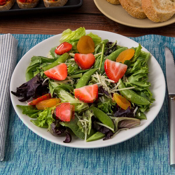 A Tuxton Zion matte white china plate with a salad of strawberries and cheese.