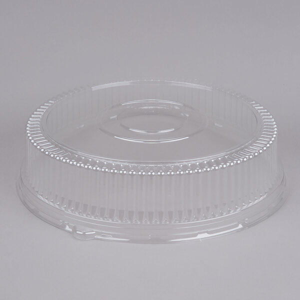 A clear plastic lid with a circular design on a white background.