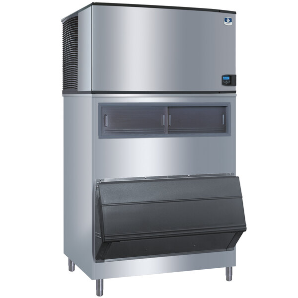 A large stainless steel Manitowoc ice machine with a stainless steel bin adapter.