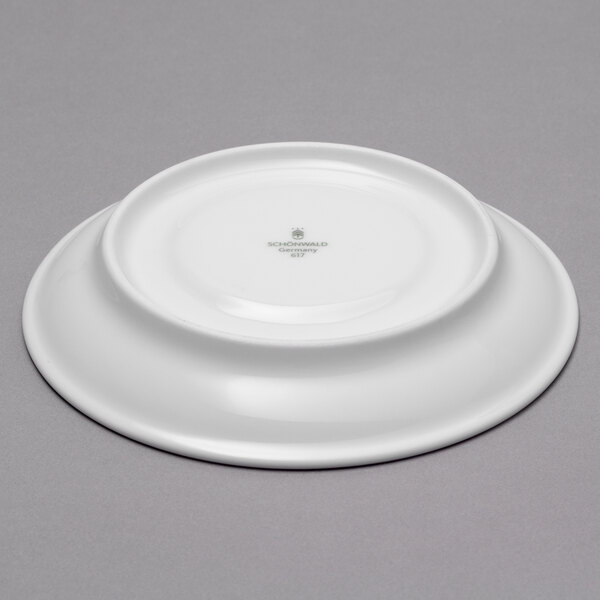 A dark blue round porcelain saucer with a color gradient on a white plate.