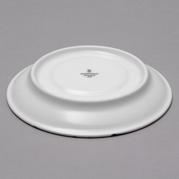 A white Schonwald porcelain saucer with green text on it.